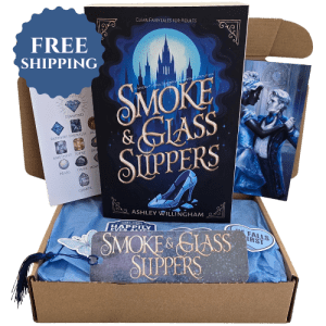 A picture of a book box containing a paperback copy of Smoke and Glass Slippers by Ashley Willingham and swag with a badge that reads "Free Shipping"
